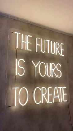 a neon sign that says the future is yours to create on it's wall