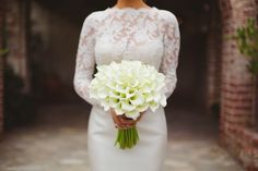 a bride holding a bouquet of white flowers