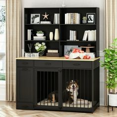 a dog sits in its kennel next to a bookcase