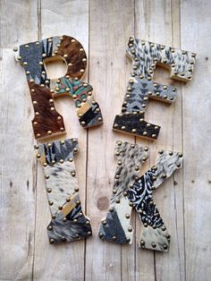 the letters are decorated with animal print and rivets on wooden planked boards