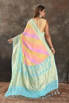 Be vision of elegance on special occasions in this alluring pastel multicolor georgette Banarasi sari. The saree is enhanced with zari buta and blue zari border. It comes with a matching blouse piece. Disclaimer: The shown stitched blouse on the model is for display purpose only. The saree comes with a matching blouse piece and finished with fall and piko. DISCLAIMER: The actual product may vary slightly from the image. These are custom orders, hence expect slight variation in color and placemen Georgette Banarasi Saree, Banarasi Sari, Sarees Banarasi, Indian Saree