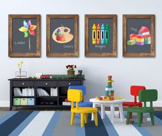 three children's artwork hanging on the wall next to a table and chairs in a room