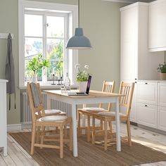 a kitchen table with chairs and a laptop on it