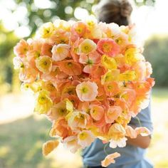 a woman holding a bouquet of flowers in her hands