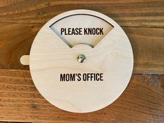 a sign that says please knock mom's office on the side of a wooden wall