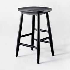 a black stool on a white background with the seat up and one foot in the air