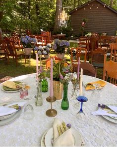 the table is set with candles, plates and napkins