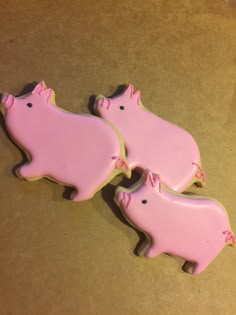 three cookies shaped like pigs sitting on top of a table