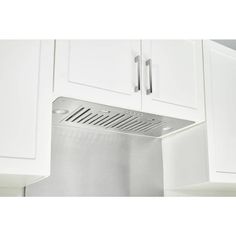 a stainless steel range hood mounted on the side of a white kitchen cabinet with cupboards