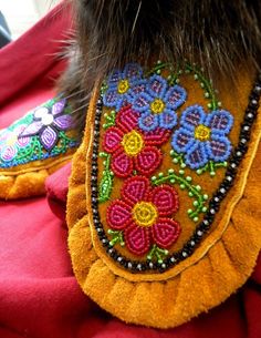 the back end of a dog's shoes with embroidered flowers on them and fur