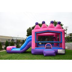 an inflatable bounce house with slide and blow up castle on the lawn at a birthday party