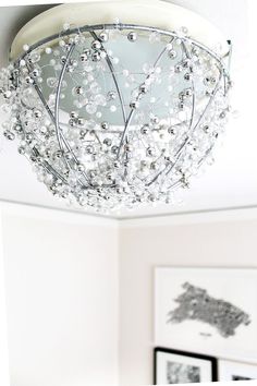 a chandelier hanging from the ceiling in a room with pictures on the wall