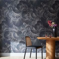 a table and chair in front of a wallpapered room with flowers on it