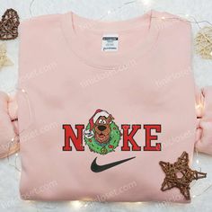 Introducing the Nike x Scooby Doo Christmas Wreath Embroidered Sweatshirt, a perfect blend of festive cheer and athletic style. This limited-edition sweatshirt showcases a meticulously crafted wreath embroidered with iconic Nike and Scooby Doo elements. Made with premium materials, it offers exceptional comfort and durability. With its unique design, this sweatshirt is a standout piece [...] Nike Inspired, Grinch Hand, Pink Coffee Cups, Maroon Hoodie, Shirt Nike, Family Christmas Gifts, Hoodie Material, Custom Nikes, Embroidered Clothes