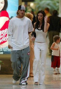 a man and woman walking through an airport