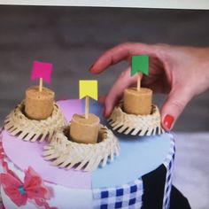 a person placing pins on the top of a cake with flags sticking out of it