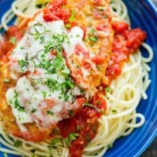 pasta with sauce and parmesan cheese on a blue plate, ready to be eaten