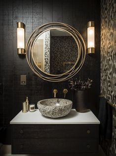 a bathroom sink with a circular mirror above it