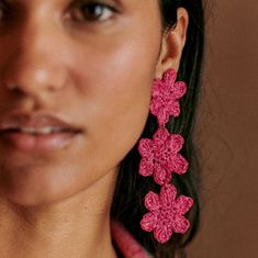 a close up of a person wearing earrings with flowers on it's earring