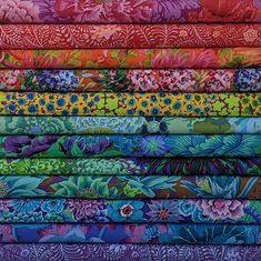 a stack of colorful fabrics with flowers on them