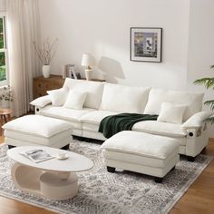 a living room filled with white furniture and a rug on top of a hard wood floor