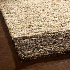 a brown and white rug on top of a wooden floor