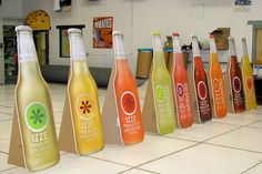 several bottles of juice are lined up on the floor