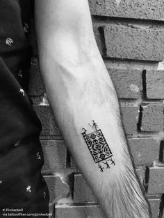 a black and white photo of a person's arm with a tattoo on it