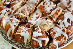 a plate full of cinnamon rolls covered in icing