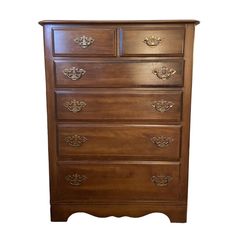 a wooden dresser with many drawers on it's sides and an ornate design at the top