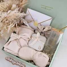 an open box containing baby's clothes and other items, including a bottle of cologne