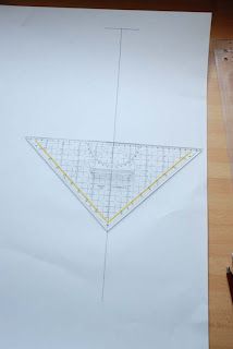 a piece of paper with a triangle drawn on it next to some scissors and pencils