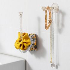 there are two necklaces hanging on the wall next to each other and one has a yellow bow