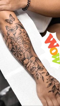 a woman's arm with flowers and butterflies on it