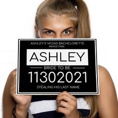 a woman holding up a sign that says ashley bride to be 1300201 stealing his last name