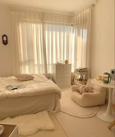 a bedroom with white furniture and curtains