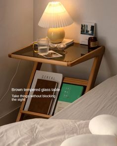 a table with a lamp on top of it next to a book and some books