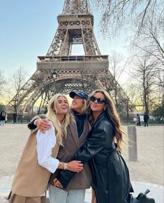 two women taking a selfie in front of the eiffel tower, paris