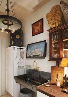 a kitchen with an old fashioned sink and lots of pictures on the wall above it