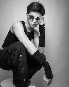 a woman sitting on top of a toilet wearing sunglasses