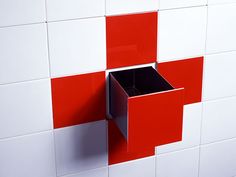 a red and white tiled wall with a black box