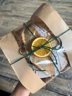 an orange slice wrapped in brown paper and tied with twine on top of a piece of bread