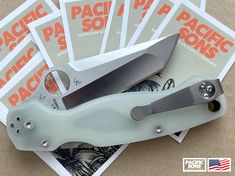 a pair of knifes sitting on top of each other next to some pamphlets for pacific pf souvenirs