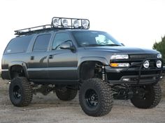 a black truck with four wheels parked in the dirt