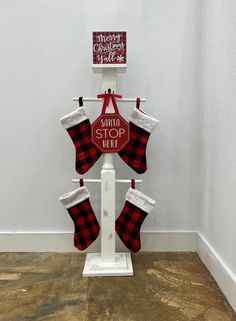 a christmas stocking holder with stockings hanging from it's sides and a merry christmas sign on top