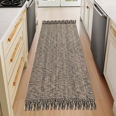 a kitchen area with a rug on the floor next to an oven and dishwasher