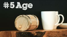 a wooden table topped with two mugs and a piece of wood next to it