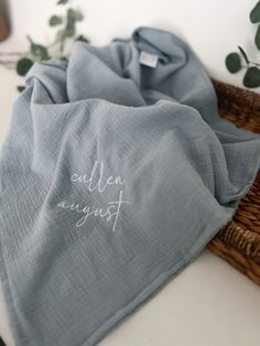 a blue blanket sitting on top of a table next to a basket filled with plants