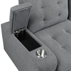 a grey couch with an open drawer in the middle