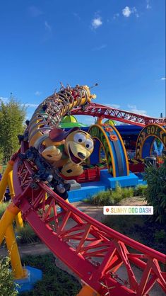 an amusement park ride that is red and yellow with cartoon characters on the top of it